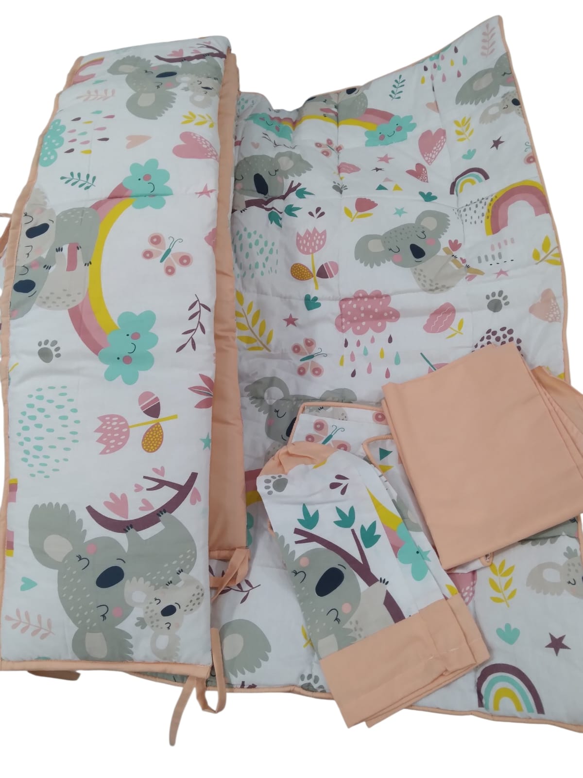 Koala and rainbow print quilted cot bedding set with peach trim