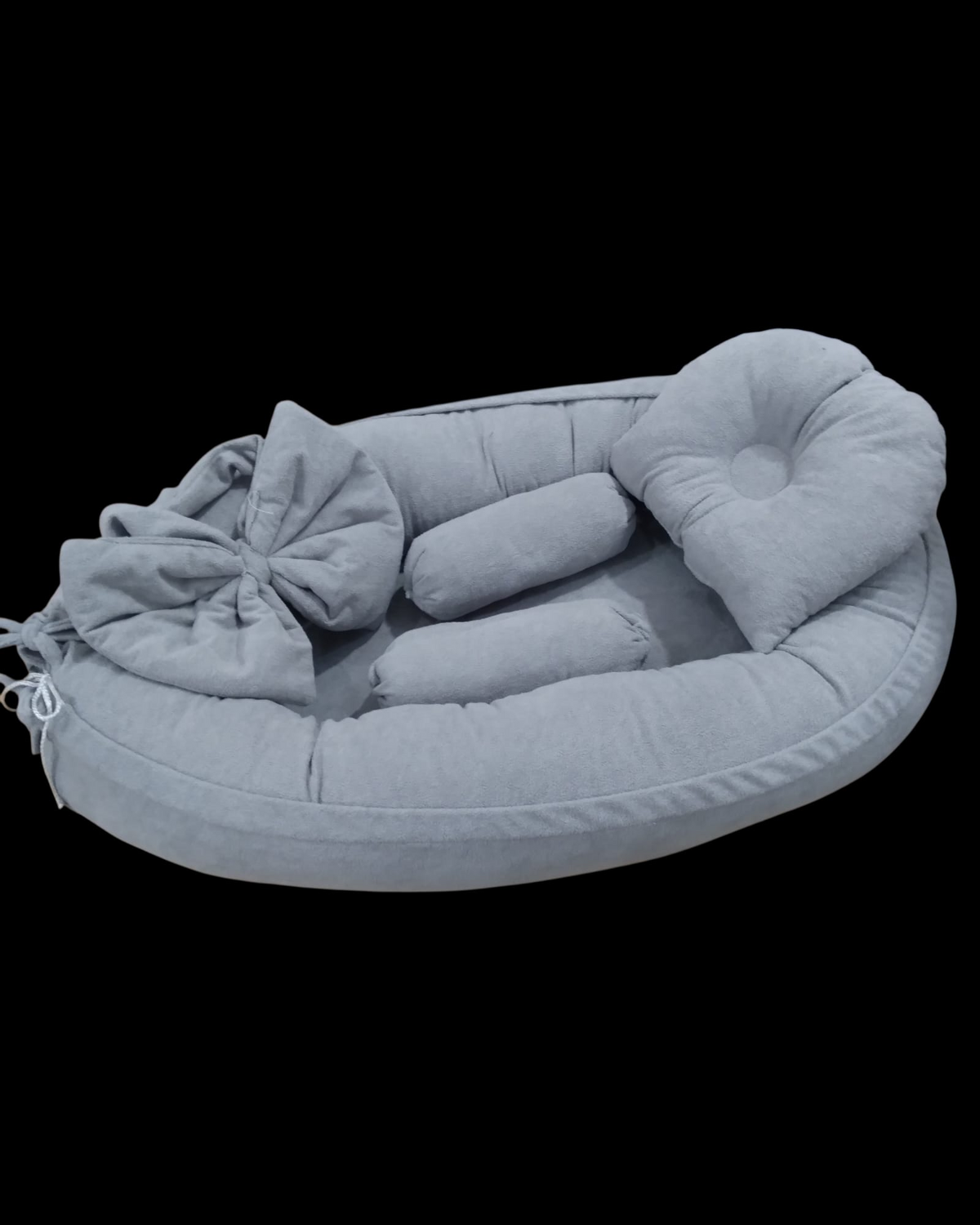 Grey baby nest with a large bow, shaped head pillow and two bolsters