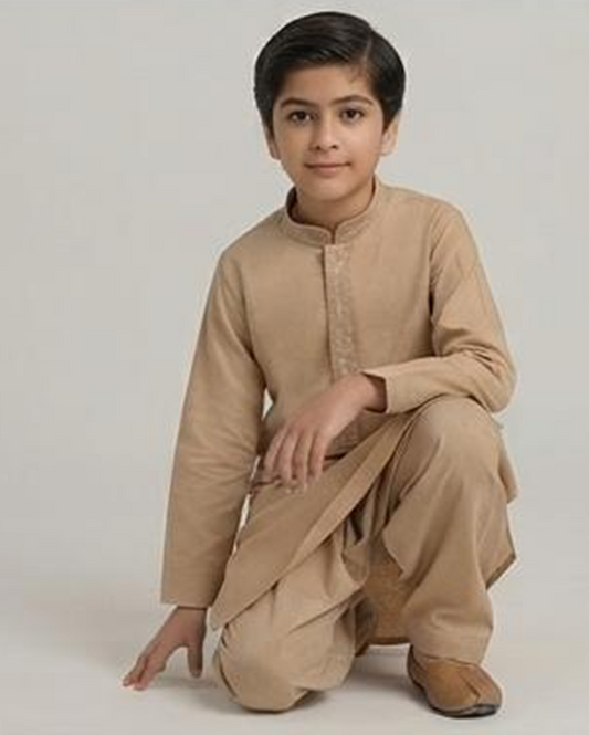 Boy wearing the beige winter shalwar kameez, kneeling